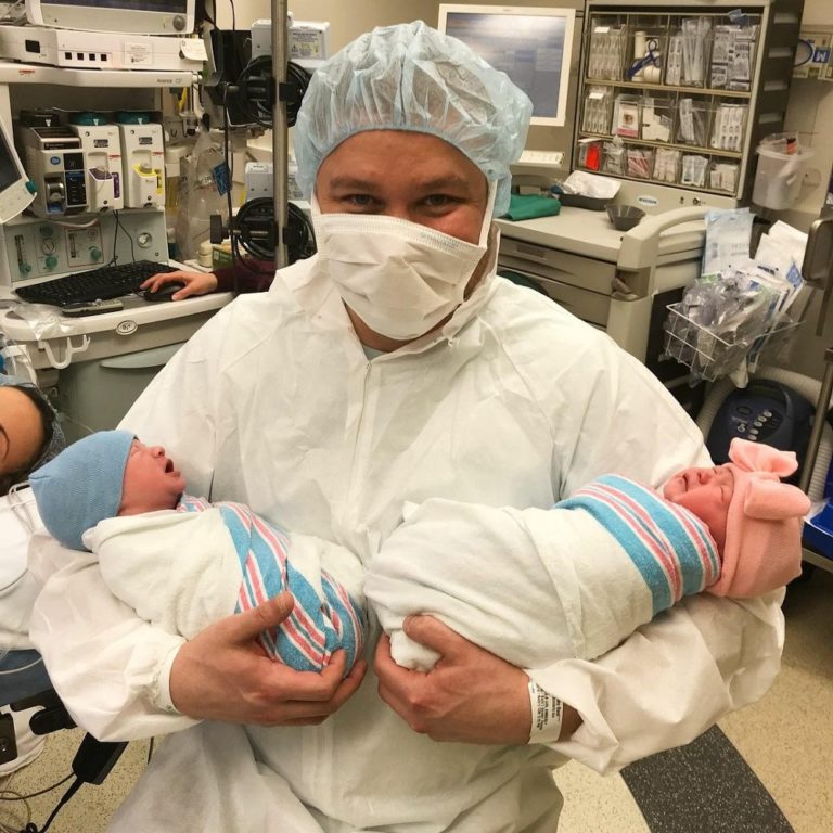 Jake holding newborn twins in delivery room